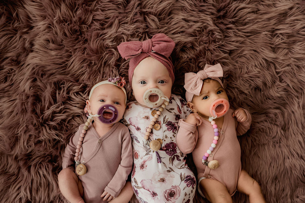 Three adorable babies each with a ninni pacifier