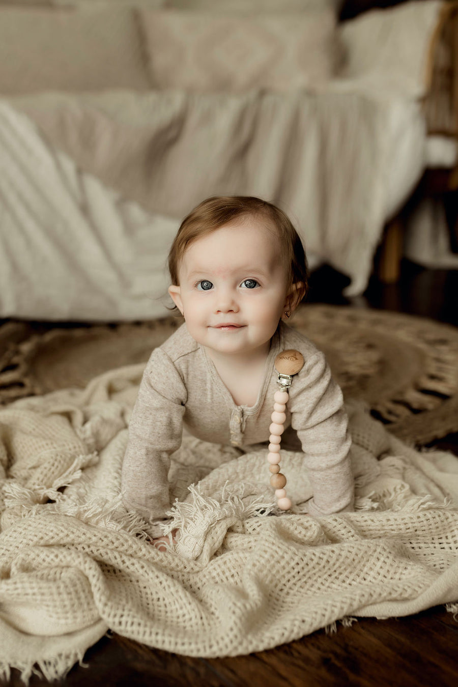 Ninni Co. Rosebud Pacifier Clip attached to a baby's shirt.